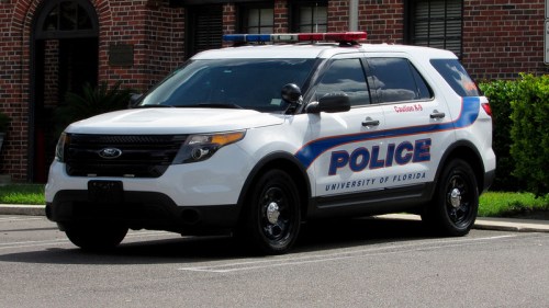 A University of Florida police SUV parked outside a building, featuring blue and red lights on top.