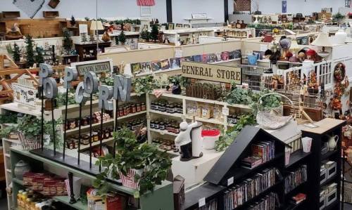 A spacious store filled with various goods, including decorations, food items, and DVDs, arranged in aisles.