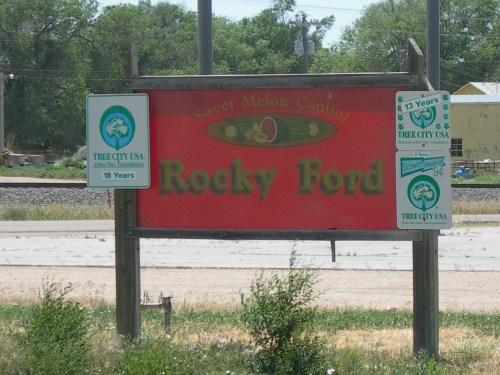 Sign for Rocky Ford, labeled "Sweet Melon Capitol," with Tree City USA recognition signs.
