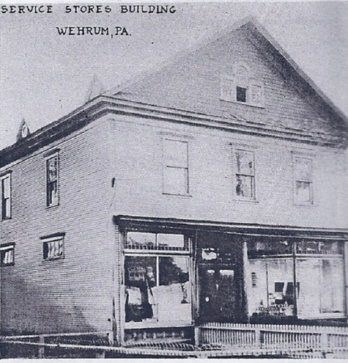 Historic black-and-white photo of the Service Stores Building in Wehrum, PA, featuring a two-story structure.