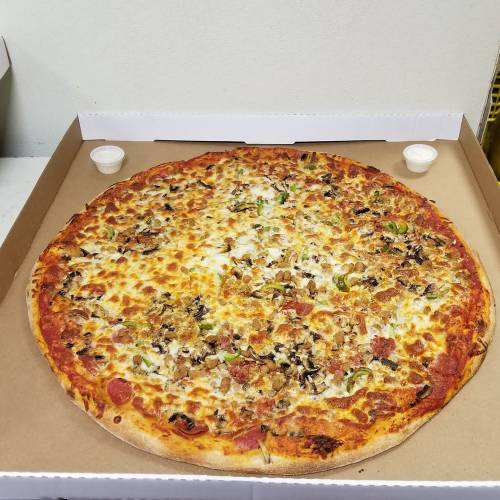 A large pizza in a box, topped with cheese, pepperoni, vegetables, and served with two small dipping sauces.