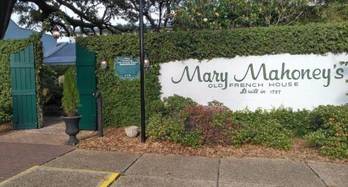 Entrance to Mary Mahoney's Old French House, surrounded by greenery, with a sign indicating its establishment in 1737.