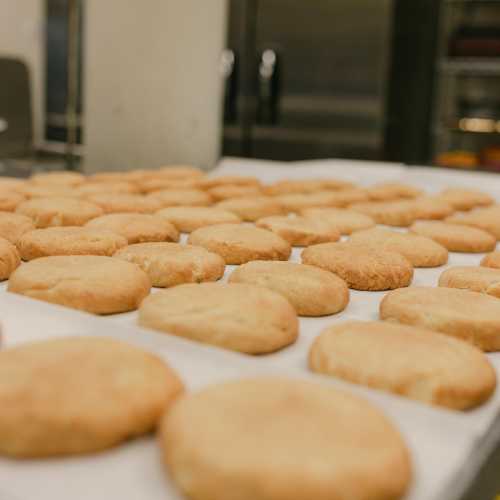 A tray of freshly baked cookies cooling on a countertop in a kitchen.