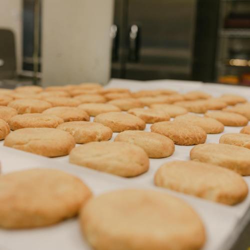 A tray of freshly baked cookies cooling on a countertop in a kitchen.