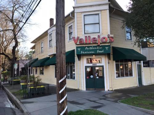 A yellow building with green awnings, featuring a sign that reads "Vallejo's Authentic Mexican Food."