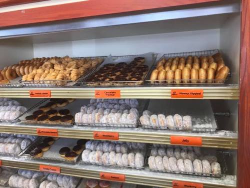 A display case filled with various types of donuts, including glazed, jelly-filled, and chocolate-covered options.