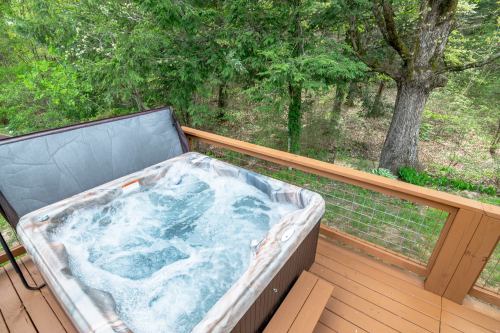 A hot tub on a wooden deck surrounded by lush green trees and nature.