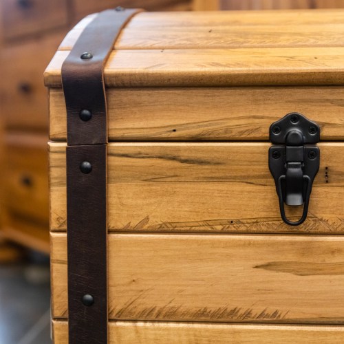 A wooden chest with a dark leather strap and a metal latch, showcasing a natural wood grain finish.