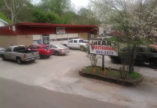 A restaurant building with a sign reading "Bear's Restaurant" and several parked cars in the lot.