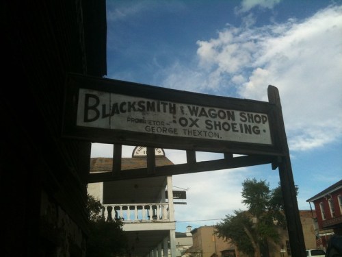 Sign for a blacksmith and wagon shop, featuring "Ox Shoeing" and the proprietor's name, George Thexton.