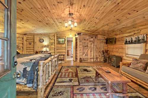 Cozy log cabin interior with wooden walls, a bed, seating area, and rustic decor, creating a warm, inviting atmosphere.