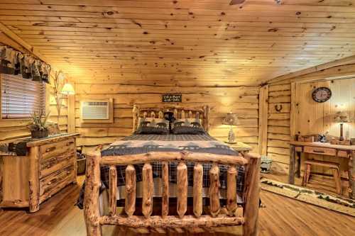 Cozy wooden bedroom with a log bed, rustic decor, and warm lighting in a cabin-style setting.