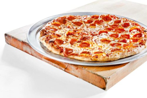 A large pepperoni pizza on a silver serving tray, resting on a wooden surface.