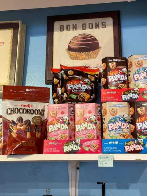 A shelf displaying various Meiji snacks, including Hello Panda and Chocorooms, with a "Bon Bons" sign above.