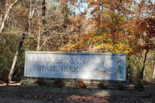 Sign for J.P. Coleman State Park surrounded by trees with autumn foliage.