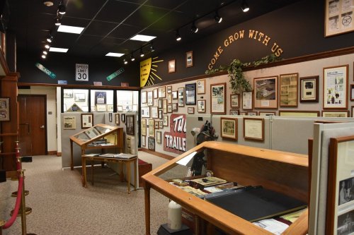Interior of a museum exhibit featuring framed documents and artifacts, with a welcoming sign on the wall.