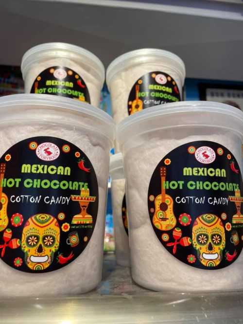 Containers of Mexican hot chocolate cotton candy, featuring colorful skull designs on the labels.