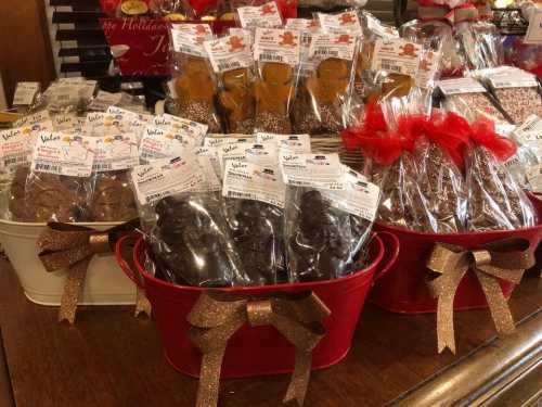 Baskets filled with packaged gingerbread cookies and chocolate treats, decorated with ribbons and tags.