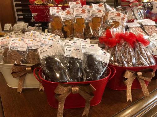 Baskets filled with packaged gingerbread cookies and chocolate treats, decorated with ribbons and tags.