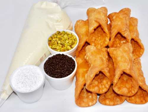 A plate of crispy pastry shells with bowls of coconut, pistachios, and a piping bag of cream.