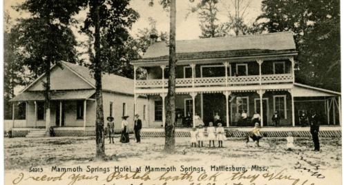 Historic photo of Mammoth Springs Hotel in Hattiesburg, Mississippi, with guests and staff outside the building.