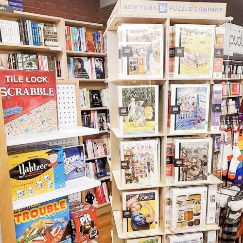 A display of puzzles and games, including Scrabble and various themed puzzles from the New York Puzzle Company.