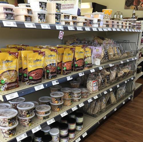 A grocery store aisle filled with various packaged grains, nuts, and snacks on shelves.