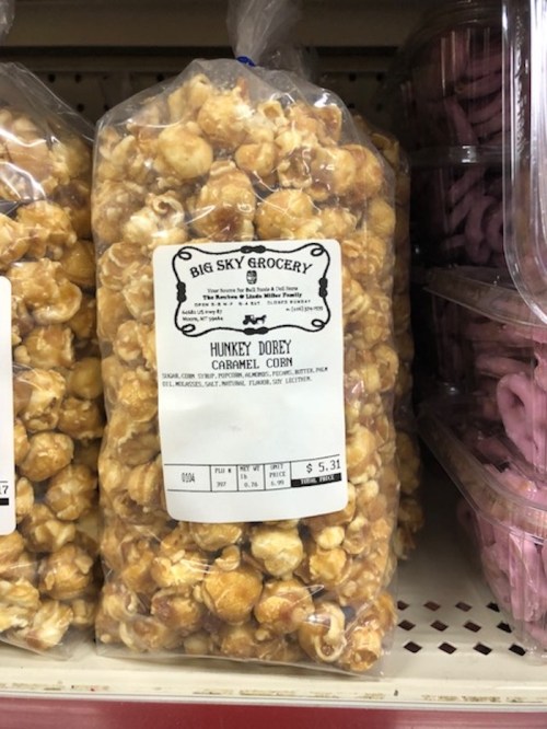 A bag of Hunkey Dorey caramel corn from Big Sky Grocery, priced at $5.31, displayed on a store shelf.
