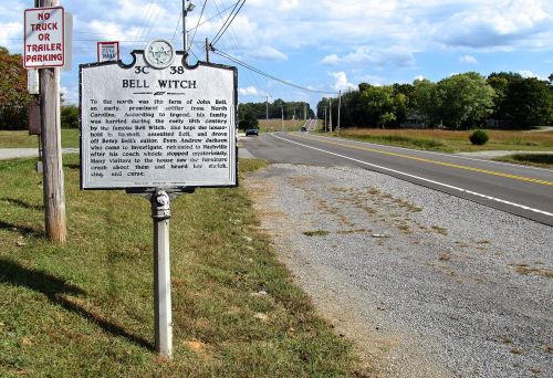 Historical marker for the Bell Witch near a rural road, with a "No Truck or Trailer Parking" sign in the foreground.