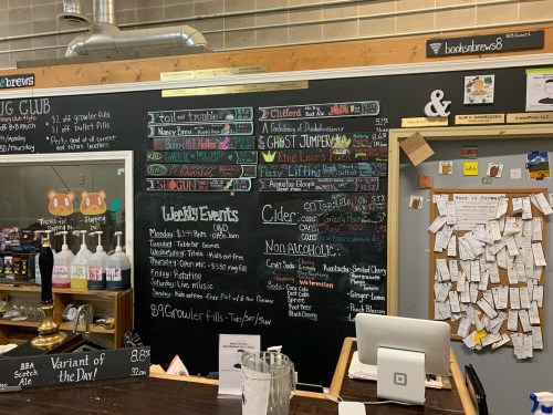 Chalkboard menu displaying events, drinks, and specials at a cozy café or bar, with colorful handwritten notes.
