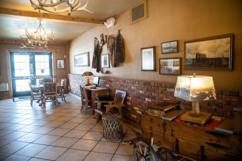 Cozy interior of a rustic room with wooden furniture, antler decor, and a warm atmosphere.