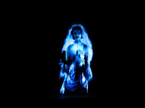 A ghostly figure of a bride in a glowing blue dress, set against a dark background.