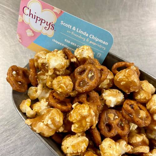 A bowl of popcorn mixed with pretzels, with a business card for Chippy's in the background.