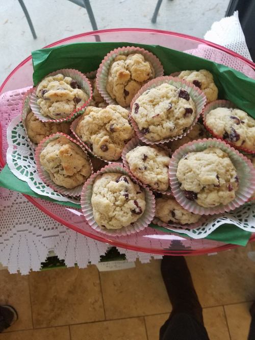 A tray of freshly baked cookies in colorful liners, arranged on a decorative plate with a lace trim.
