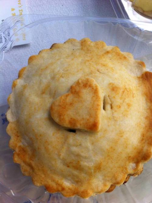 A freshly baked pie with a golden crust and a heart-shaped cutout on top.