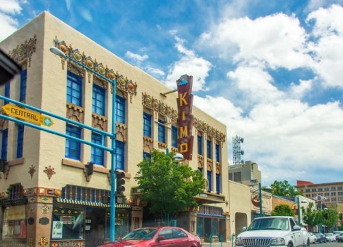 Historic Kimo Theatre building with colorful architectural details under a partly cloudy sky.