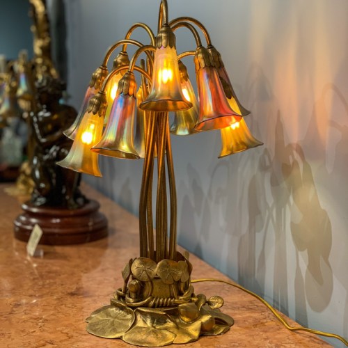 A decorative lamp with colorful glass shades shaped like flowers, resting on a leaf-shaped base.
