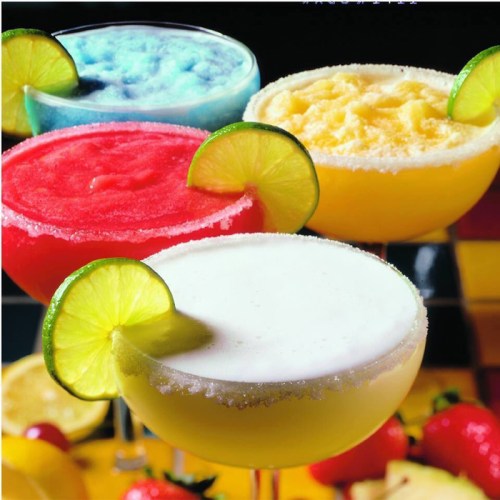 Colorful margaritas in glasses with lime slices, featuring red, blue, yellow, and white drinks on a checkered table.