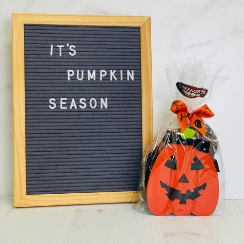 A letter board reads "It's Pumpkin Season" next to a wrapped pumpkin treat with a jack-o'-lantern face.