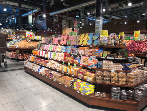 A vibrant grocery store aisle filled with various snacks, cookies, and baked goods on display.
