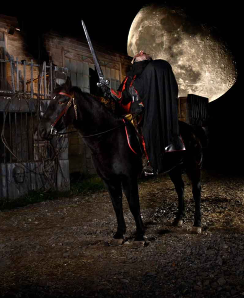 A cloaked figure on a black horse holds a sword, with a large moon illuminating a dark, eerie setting.