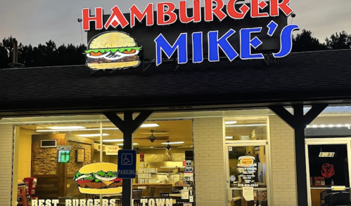 Sign for Hamburger Mike's featuring a burger graphic, with a cozy restaurant exterior and "Best Burgers in Town" slogan.