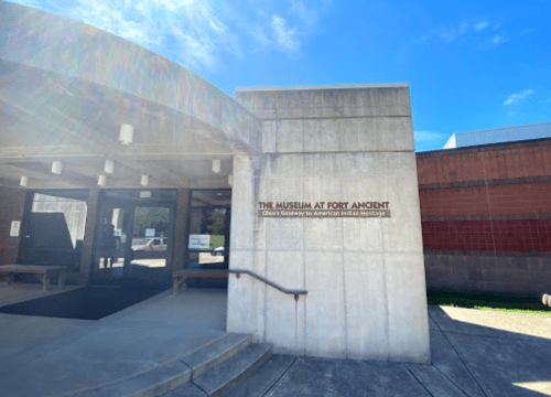 Entrance to The Museum at Fort Ancient, showcasing a modern building with a sign about American Indian heritage.