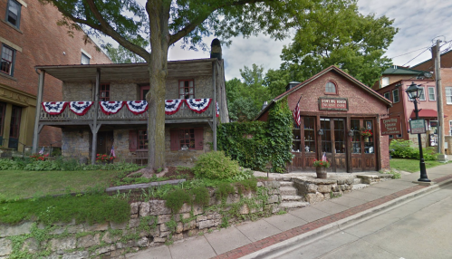 Historic buildings with patriotic decorations, surrounded by greenery and a stone pathway.