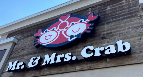 Sign for "Mr. & Mrs. Crab" featuring a cartoon crab design on a wooden background.