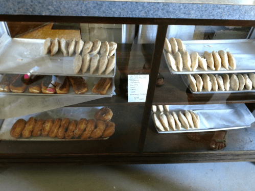A display case filled with various baked goods, including cookies and pastries, on metal trays.