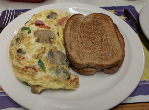 A plate with a vegetable omelette and two slices of toasted whole grain bread.
