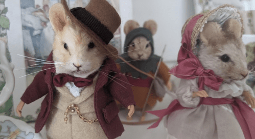 Three charming mice in vintage clothing: one in a top hat, another in a hood, and a third in a bonnet and dress.