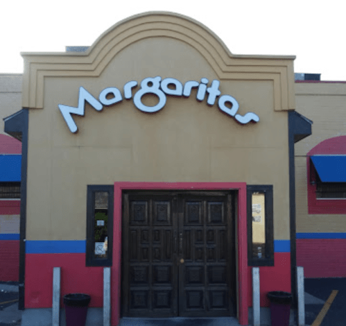 Exterior of a restaurant named "Margaritas," featuring a large sign and a wooden double door entrance.