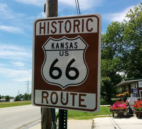 Sign for Historic Route 66 in Kansas, featuring a brown background with white text and a shield shape.